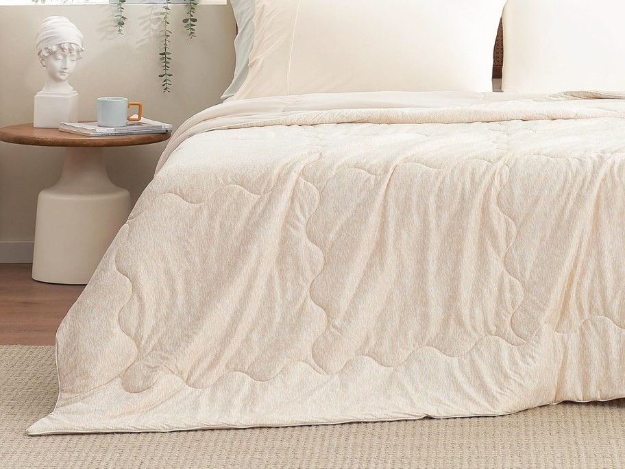 beige blanket draped over a bed