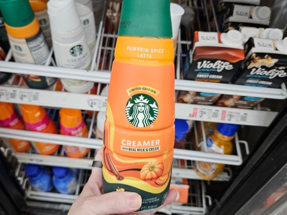 Hand holding a bottle of Starbucks Pumpkin Spice Creamer