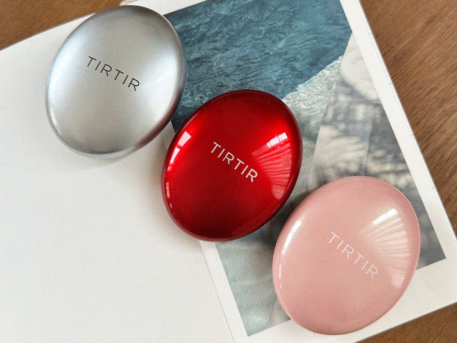 silver, red, and pink foundation compacts