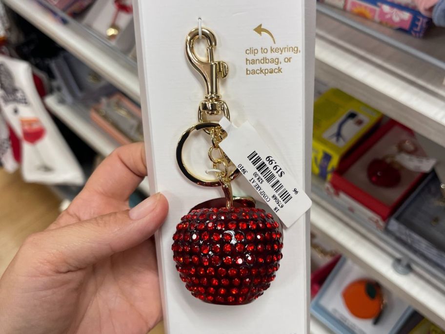 A bag charm in the shape of a shiny, bejeweled apple