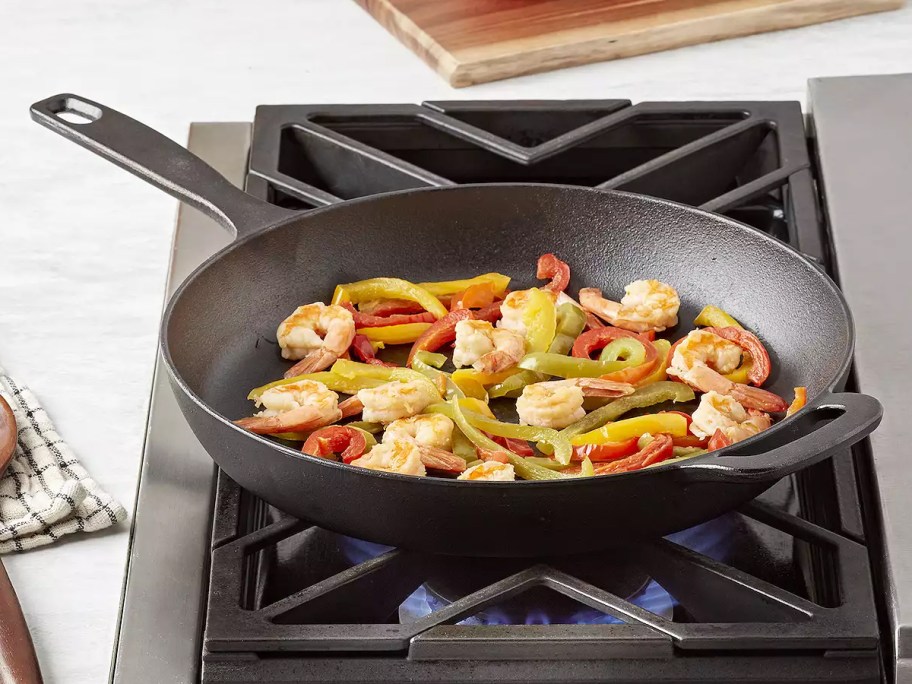 The Big One 12in Pre-Seasoned Cast-Iron Skillet on a stove top with food