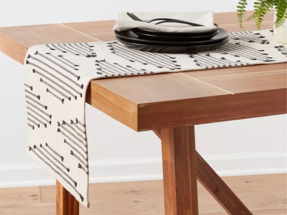 A table with a Threshold Cotton Modern Diamond Table Runner
