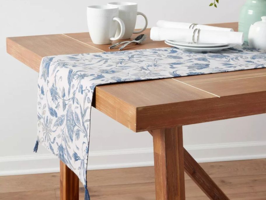 A table with a Threshold Cotton Blue Floral Table Runner