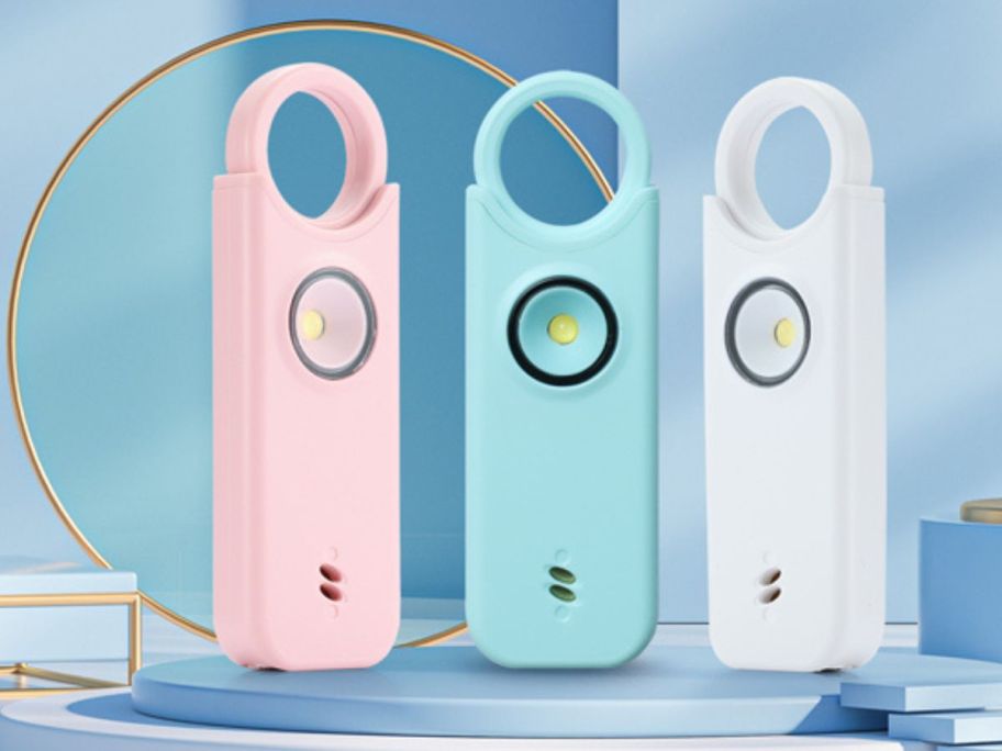 3 personal safety alarms in pink, blue, and white