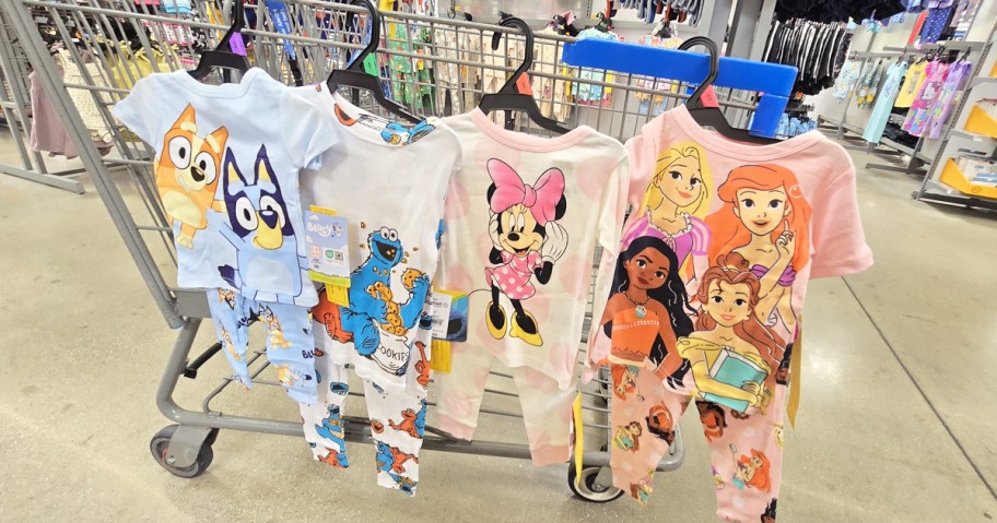 bluey, sesame street, minnie mouse, and disney princess pajama sets hanging from cart