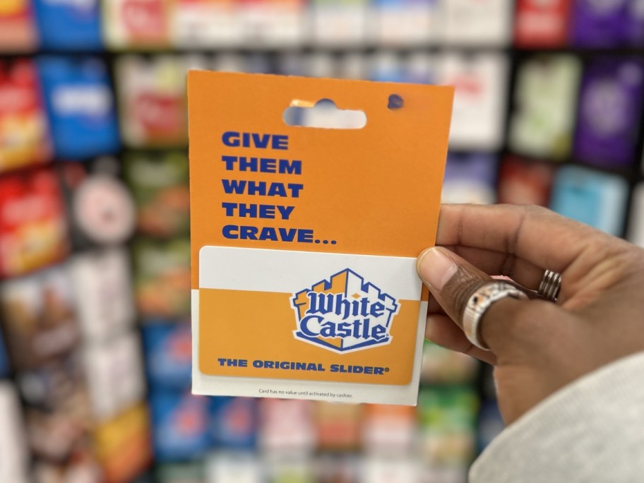 person holding white castle gift card in store