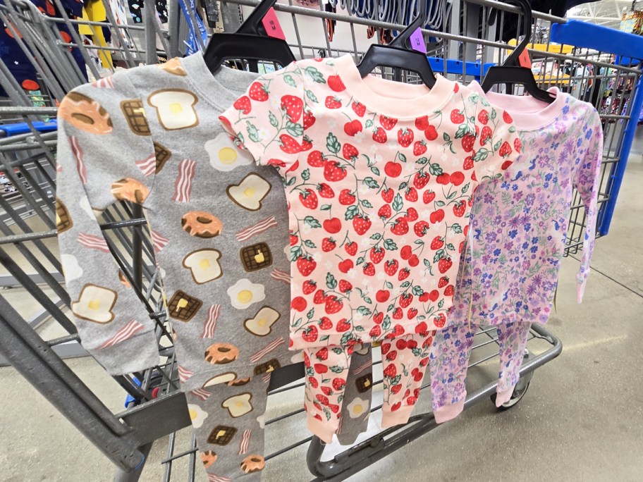 breakfast, strawberry, and floral print pajama sets hanging from a cart