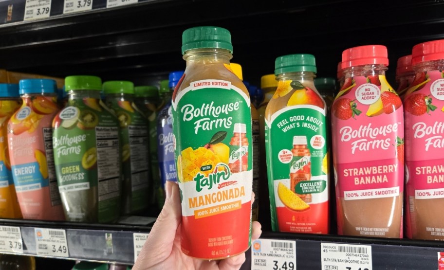 a womans hand holding a bottle of smoothie