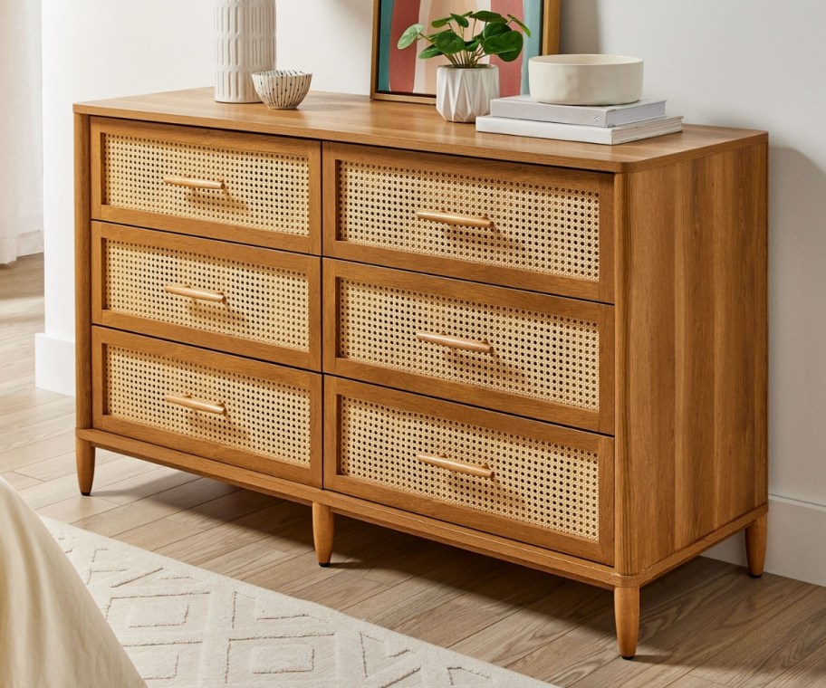 a honey colored wood dresser with caning on the drawers