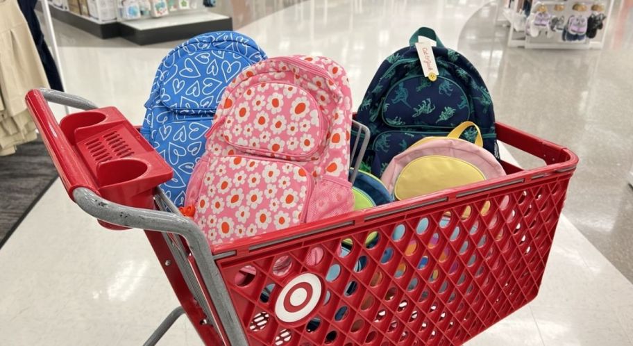 a red target cart filled with kids backpacks in various graphic prints