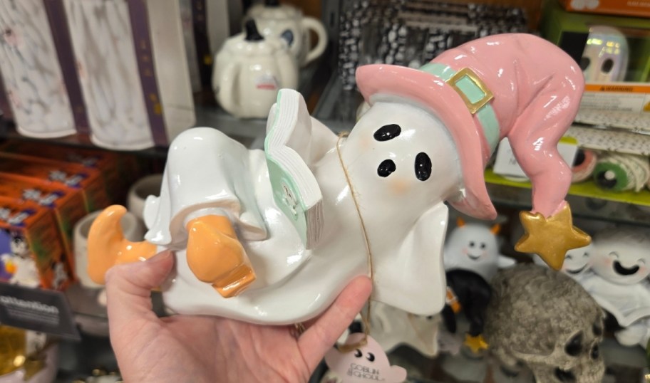 a womans hand holding a ceramic ghost