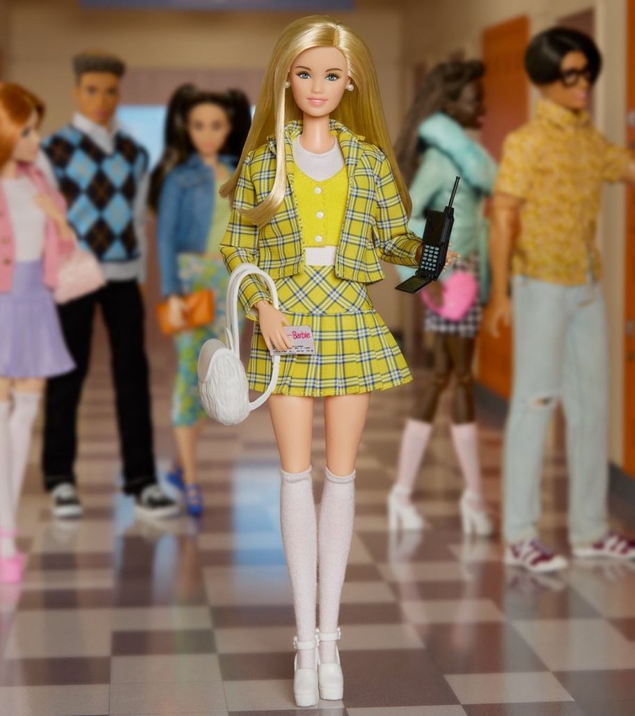 a cher barbie doll in her signature plaid suit in a school hallway