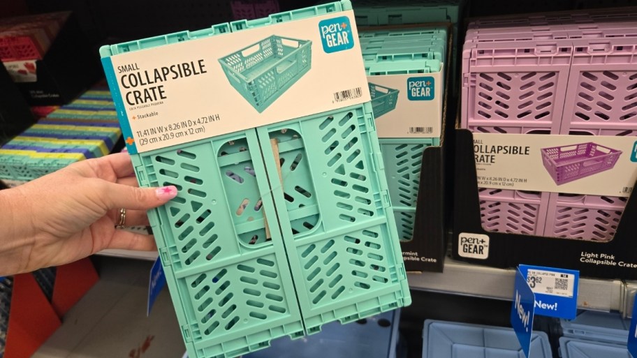 a womans hand holding a plastic collapsible crate