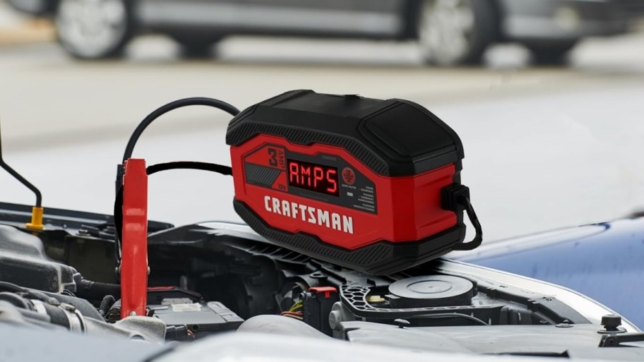 a red battery charger hooked to car battery
