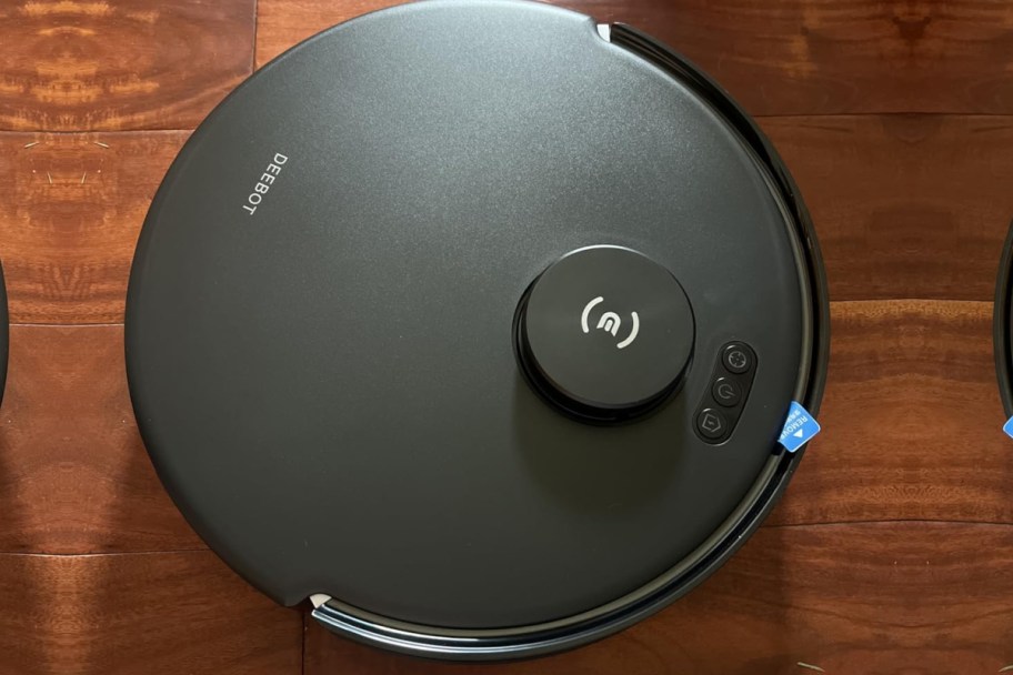 black round robot vacuum cleaner on hardwood floor