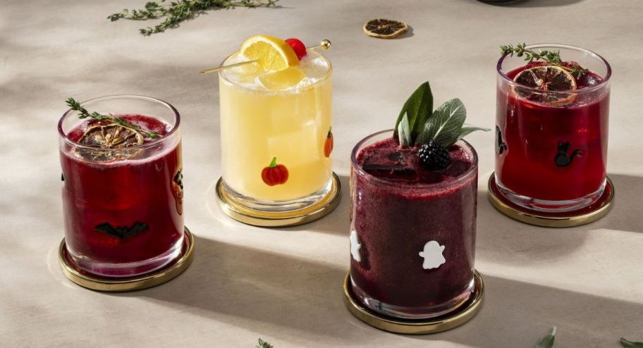 four fun glasses with a red drink inside