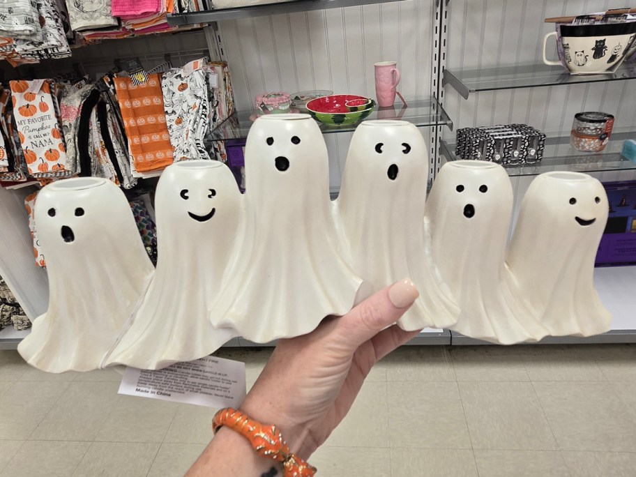 hand holding white ghost candle holder