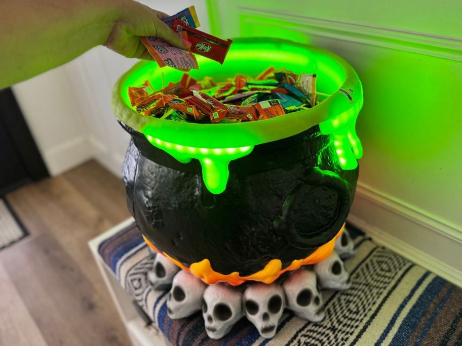 hand reaching into the caldron to take out candy