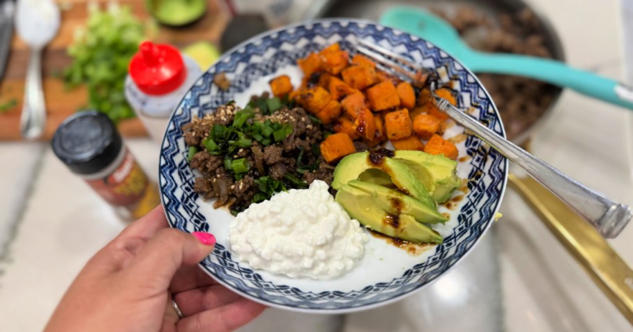 holding a ground beef and sweet potato bowl