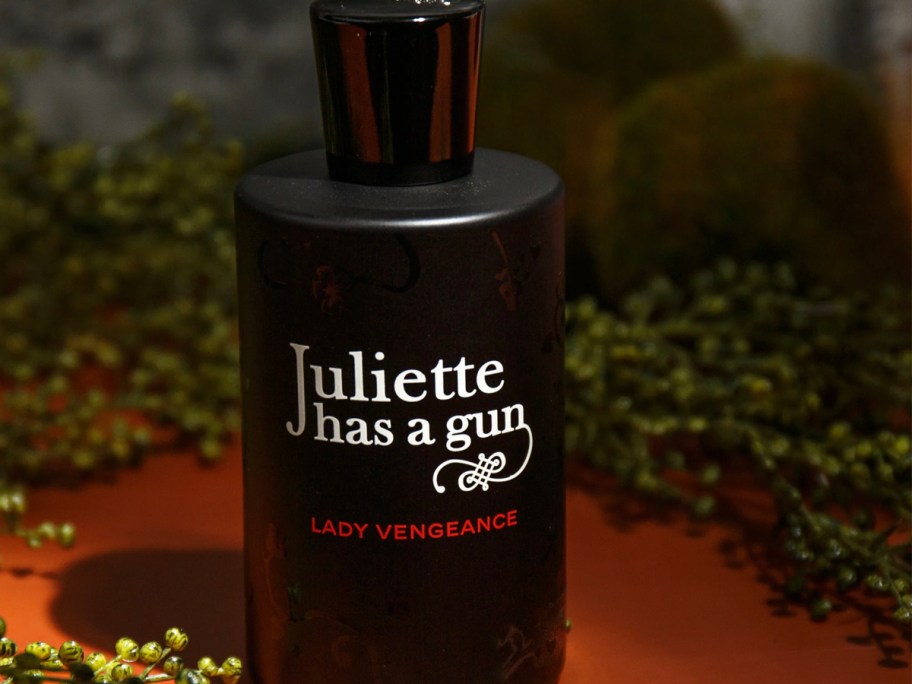 juliette has a gun perfume bottle on table with ferns