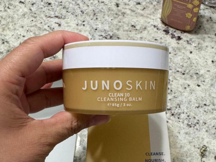 JUNO & Co Clean 10 Cleansing Balm jar in hand in bathroom