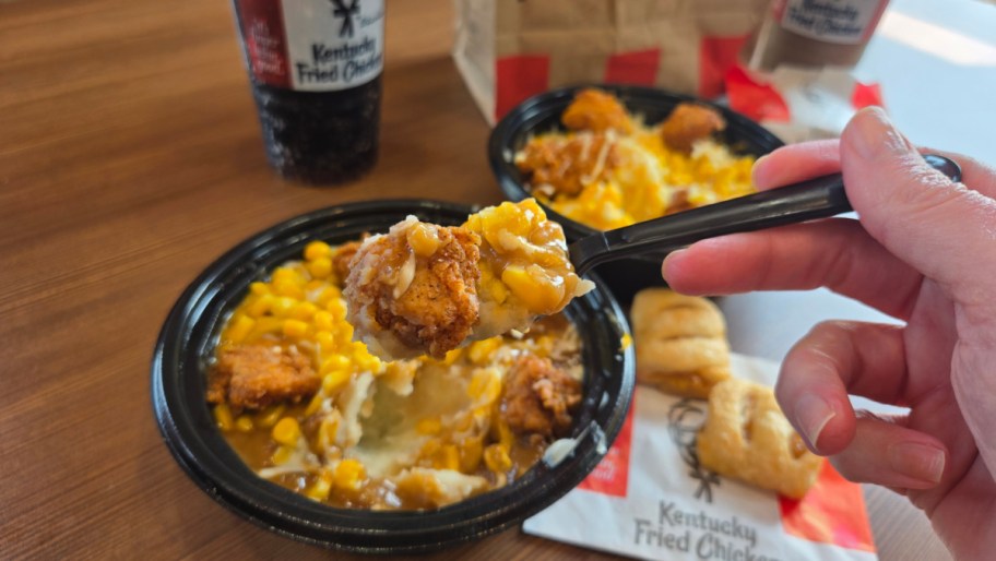 two kfc famous bowls one being dipped into with a spork