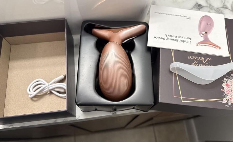 a light therapy wand in box shown with charging cord