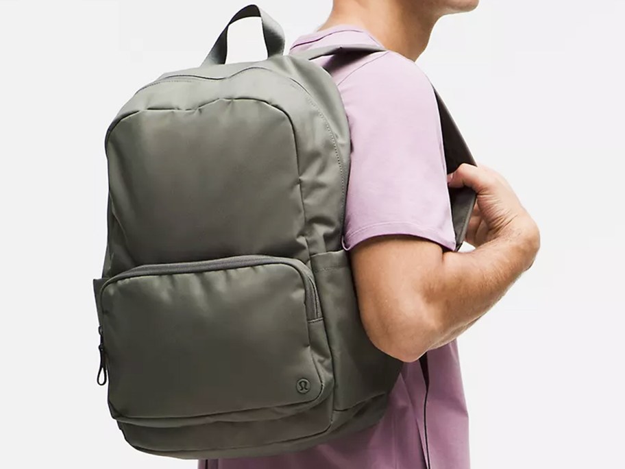 man in a pink shirt with a grey backpack
