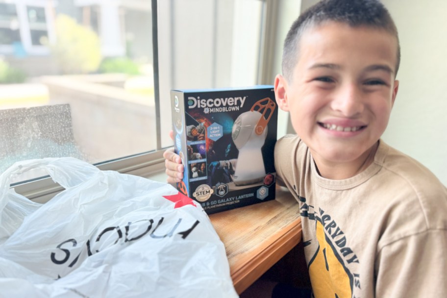 boy holding discovery planetarium toy