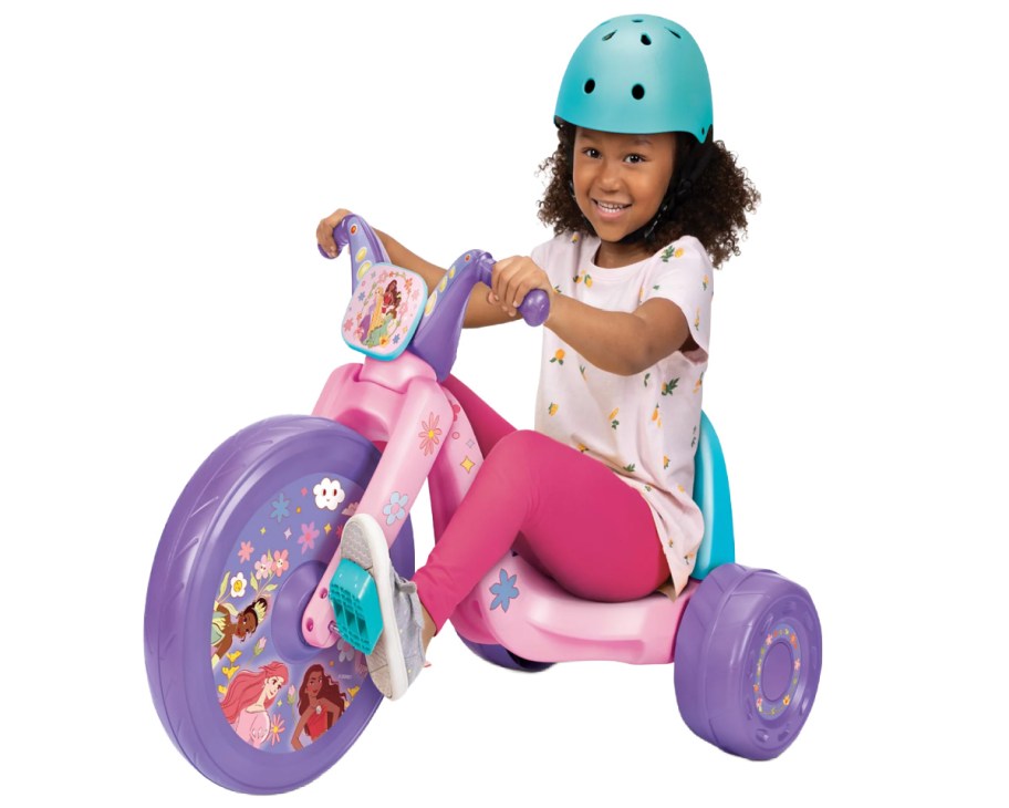 girl on pink and purple princess big wheel