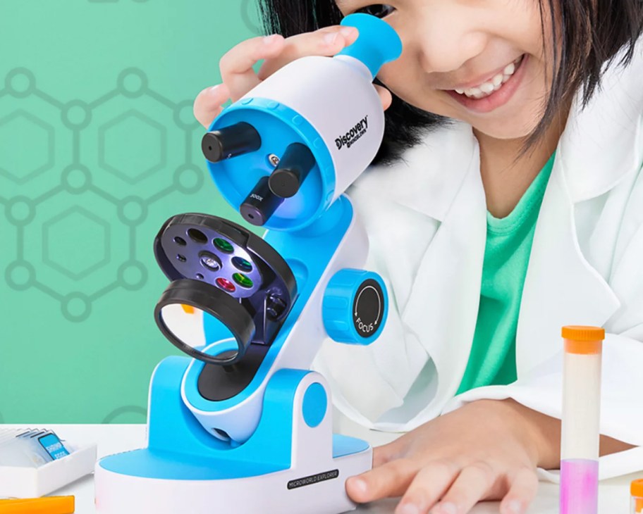 girl looking through kids microscope