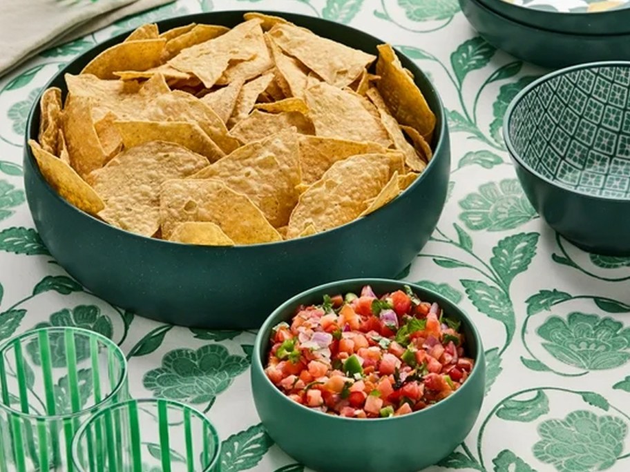 green bowls with chips and dip on table
