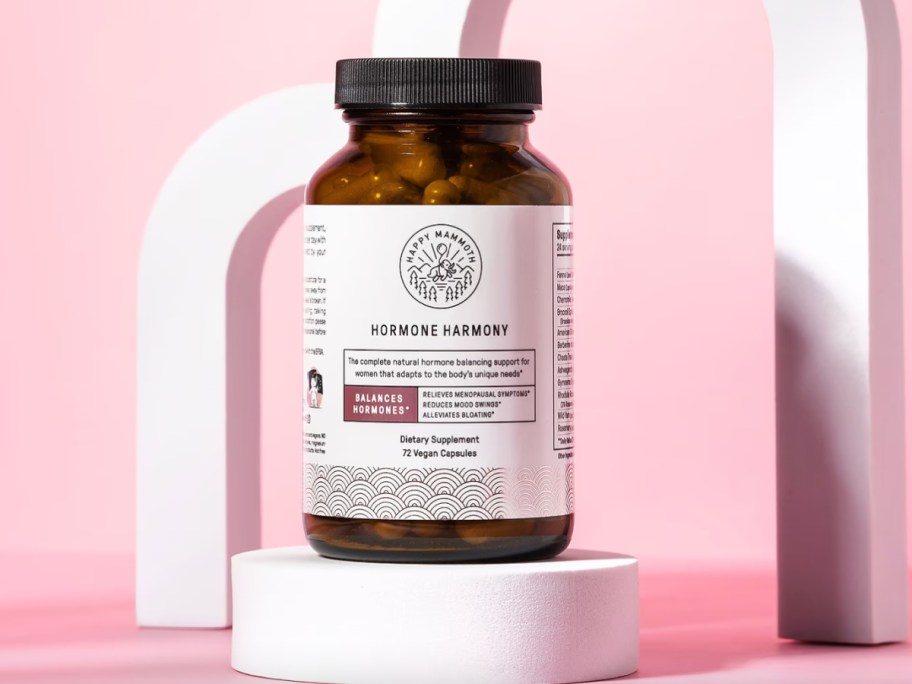 bottle of vitamins on white pedestal
