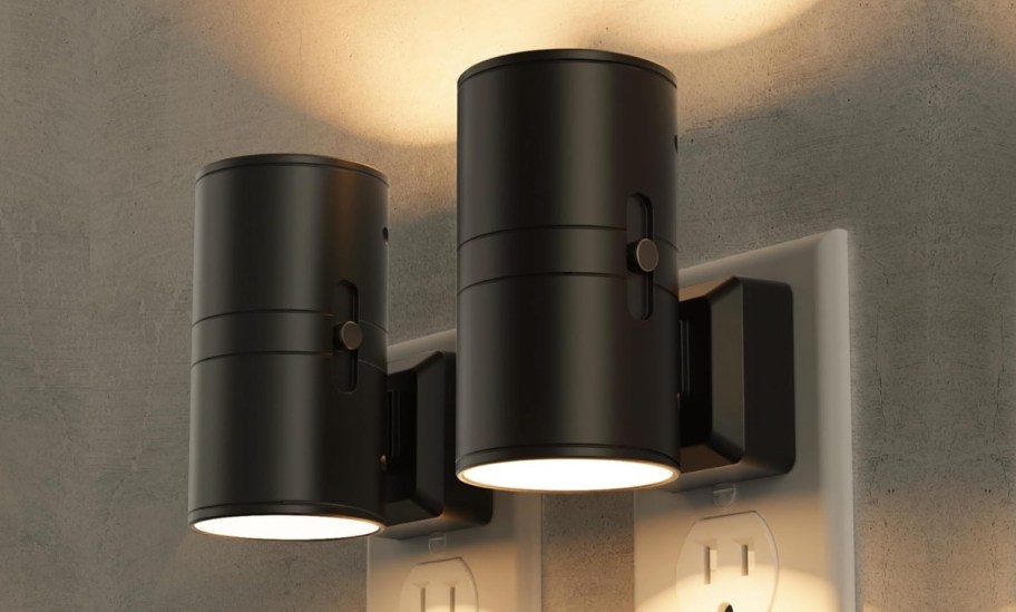 two black smart nightlights plugged into electrical receptacles