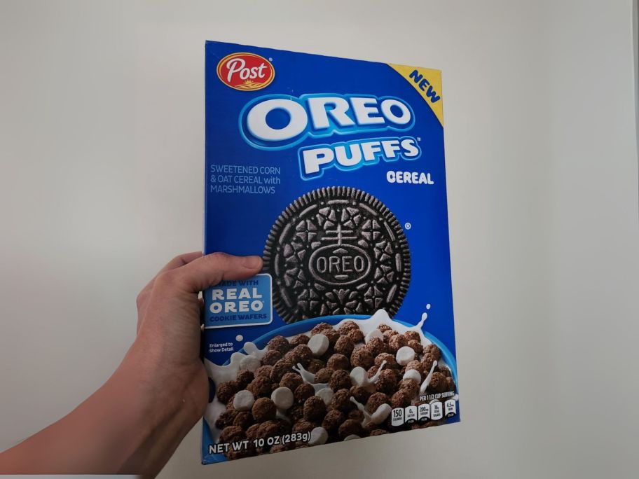 hand holding Post OREO Puffs Cereal 10oz box
