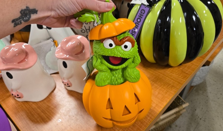 an oscar the grouch popping out of a jack o lantern figurine