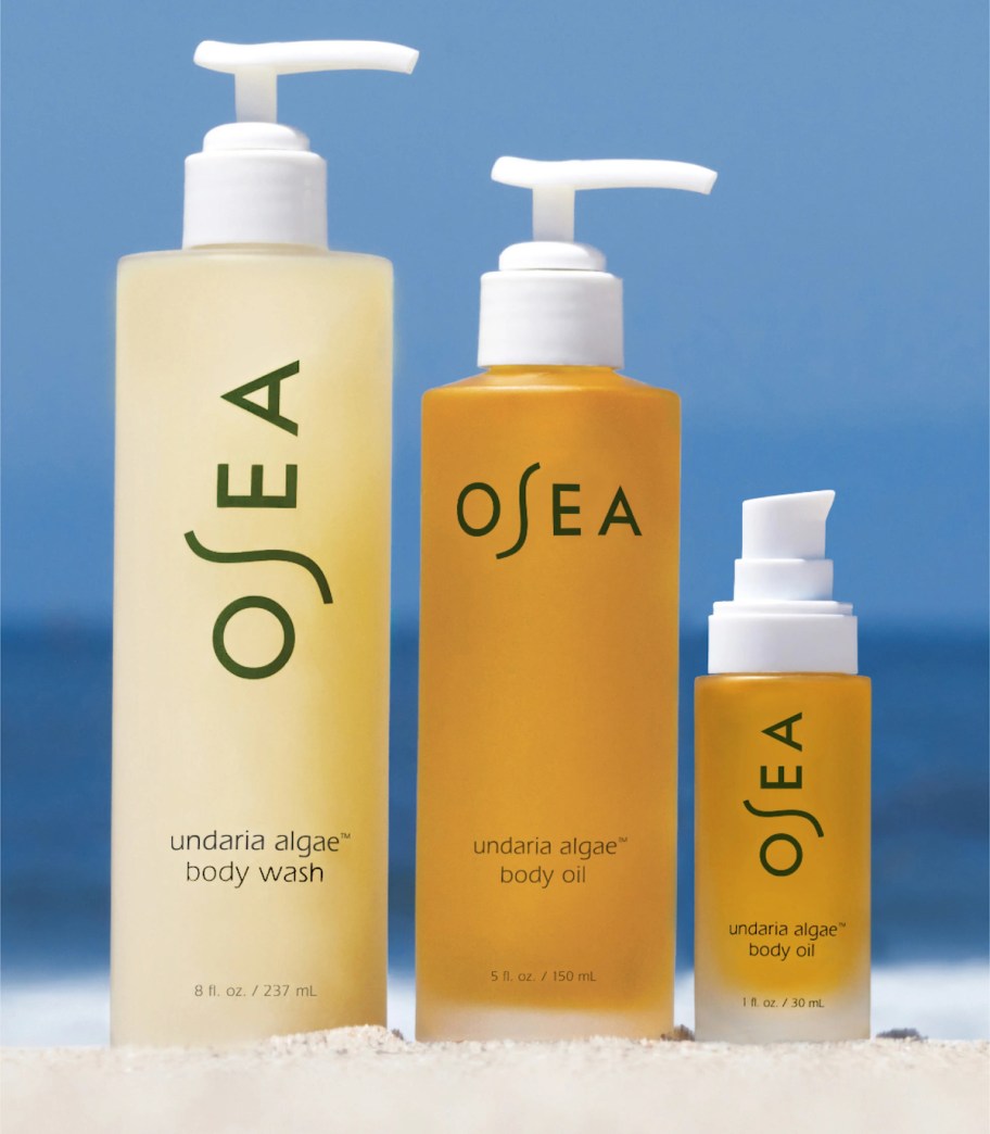 three bottles of osea beauty products on sand
