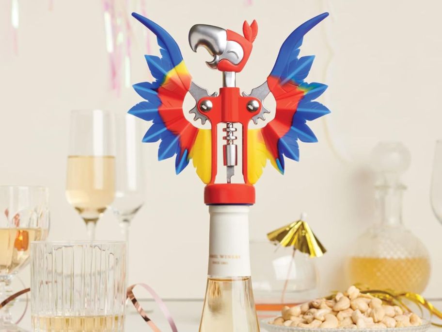 OTOTO Parrot Pinot Wine Bottle Opener amongst glasses and party decorations