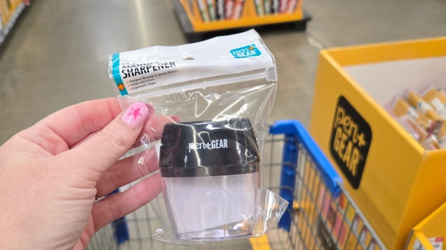 a womans hand holding plastic pencil sharpener