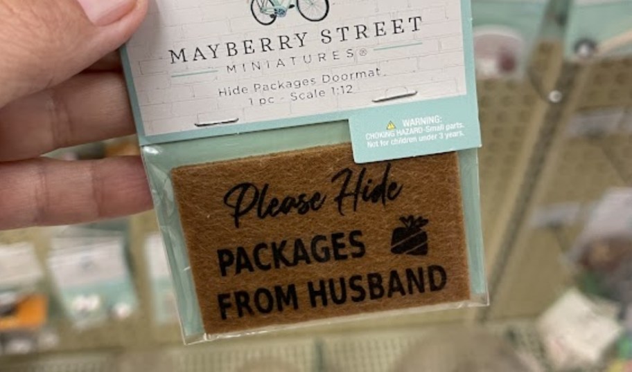 a womans hand holding a mini doormat