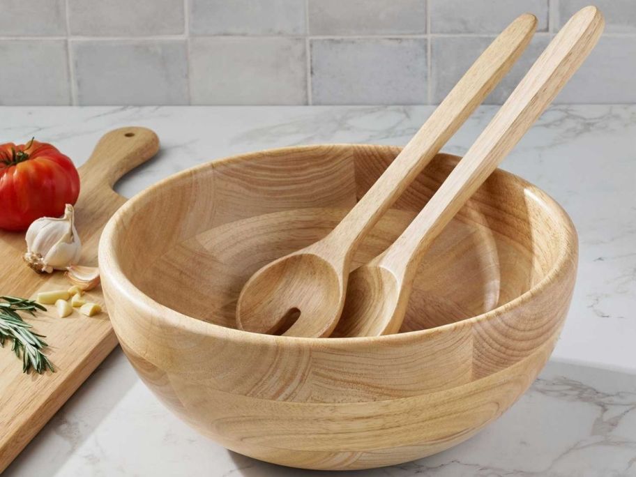 a large wooden bowl with wooden serving utenils