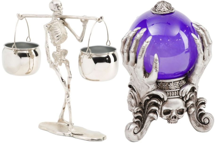 a skelton carrying two candy bowl cauldrons and a purple smoky crystal ball on a spooky stand