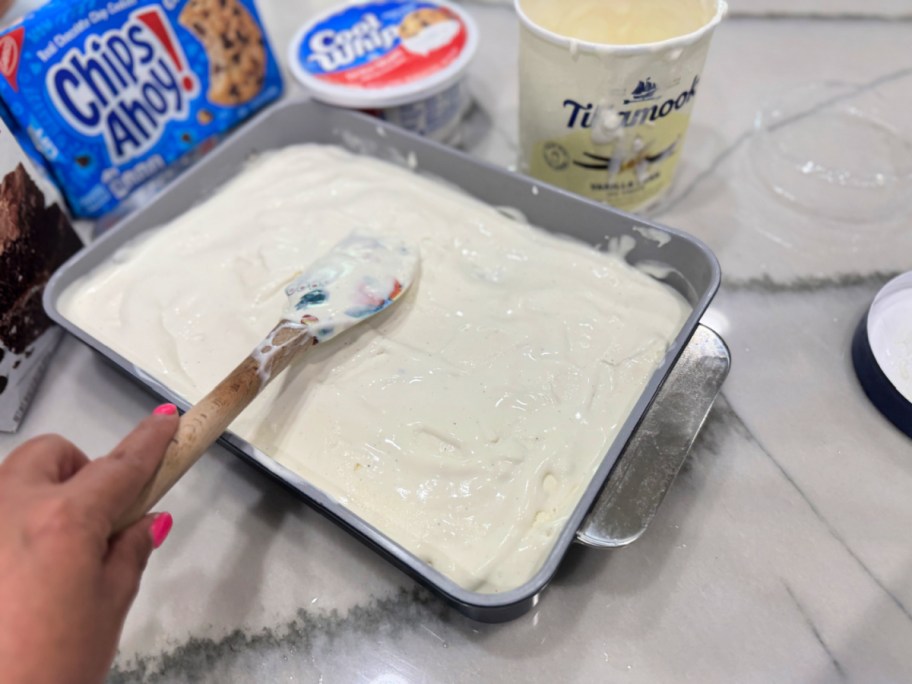 spreading softened vanilla ice cream on brownies