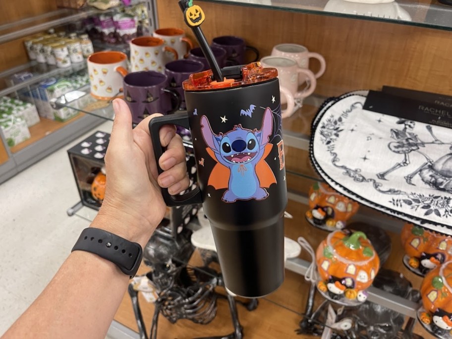 a womans hand holding a stitch tumbler