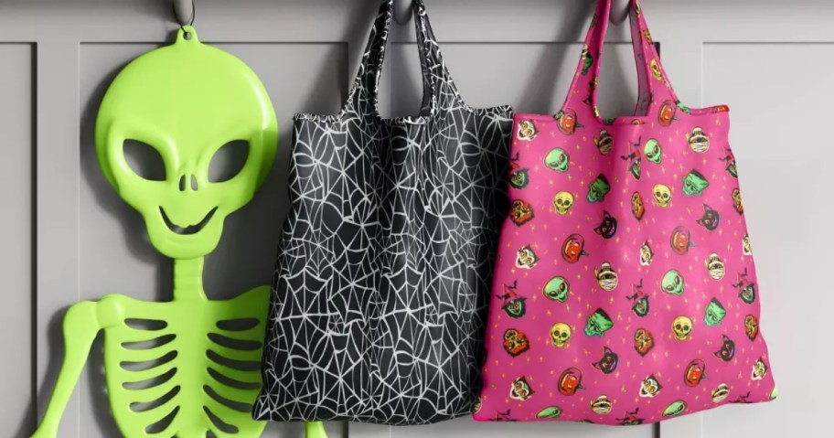 Halloween tote bags hanging on wall hooks with Halloween decor