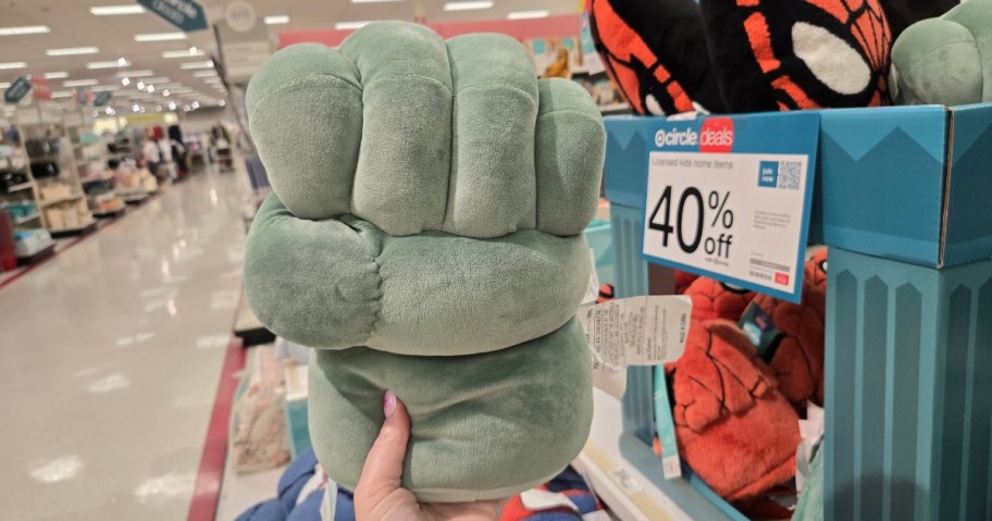hand holding a Hulk Fist throw pillow at Target