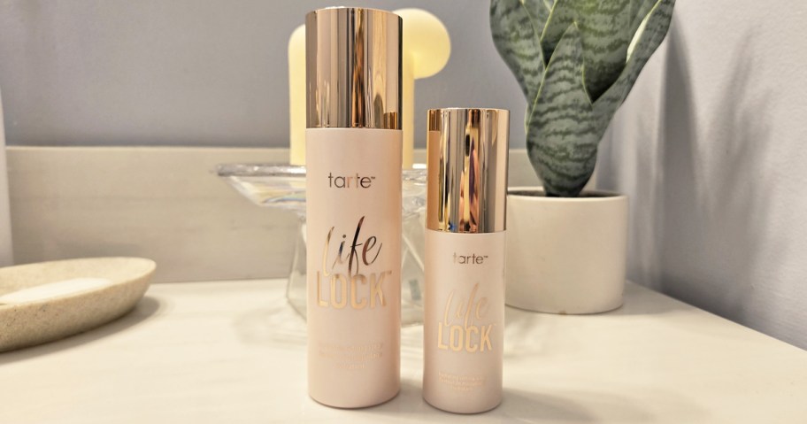 large and small pink bottles of tarte Life Lock Setting Spray on bathroom counter