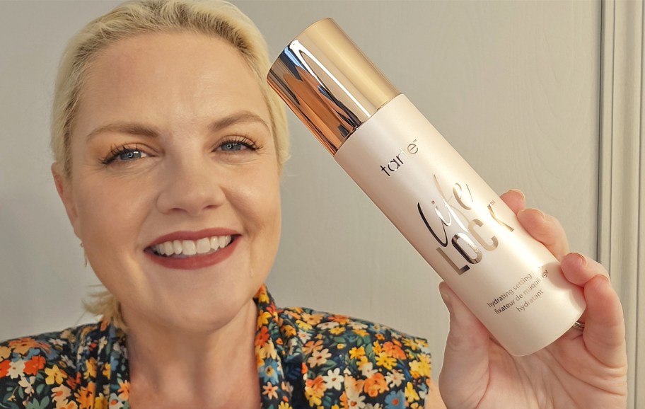 woman holding up a bottle of tarte Life Lock Setting Spray