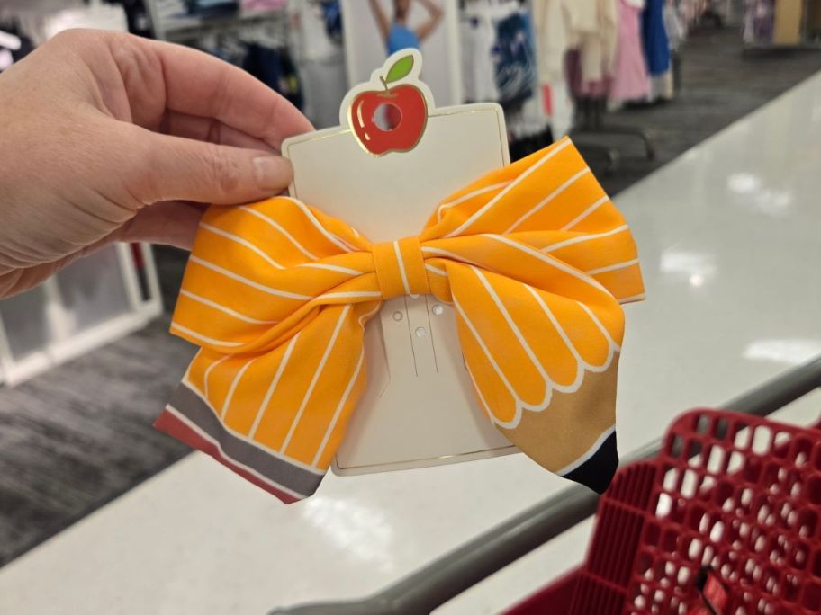 yellow Teacher Pencil Hair Bow Clip in hand in store