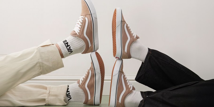 two people wearing tan vans shoes 